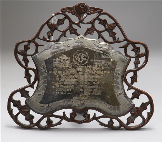 A mid 20th century Chinese white metal presentation plaque mounted on a pierced hardwood easel frame, width 32cm.